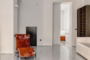 A modern interior with a metal-framed chair, a dark door, and a white sofa.