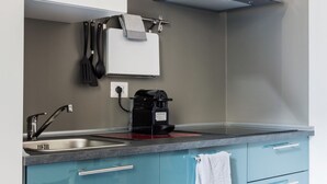 Una cucina con lavandino, macchina del caffè e porta asciugamani.