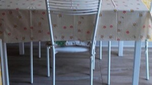 A dining area with a table set for four, chairs, and a fruit bowl on the table. - Apartment Roberto  (Gallipoli)