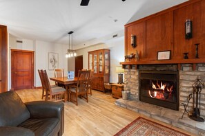 Una sala de estar con chimenea, muebles de madera y un comedor.