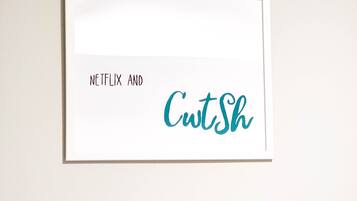 Une plaque encadrée avec le texte « NETFLIX ET CutSh » sur un fond blanc.