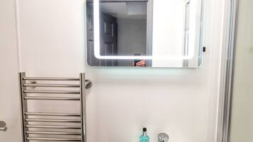 A bathroom with a white sink, a mirror, and a towel rack.