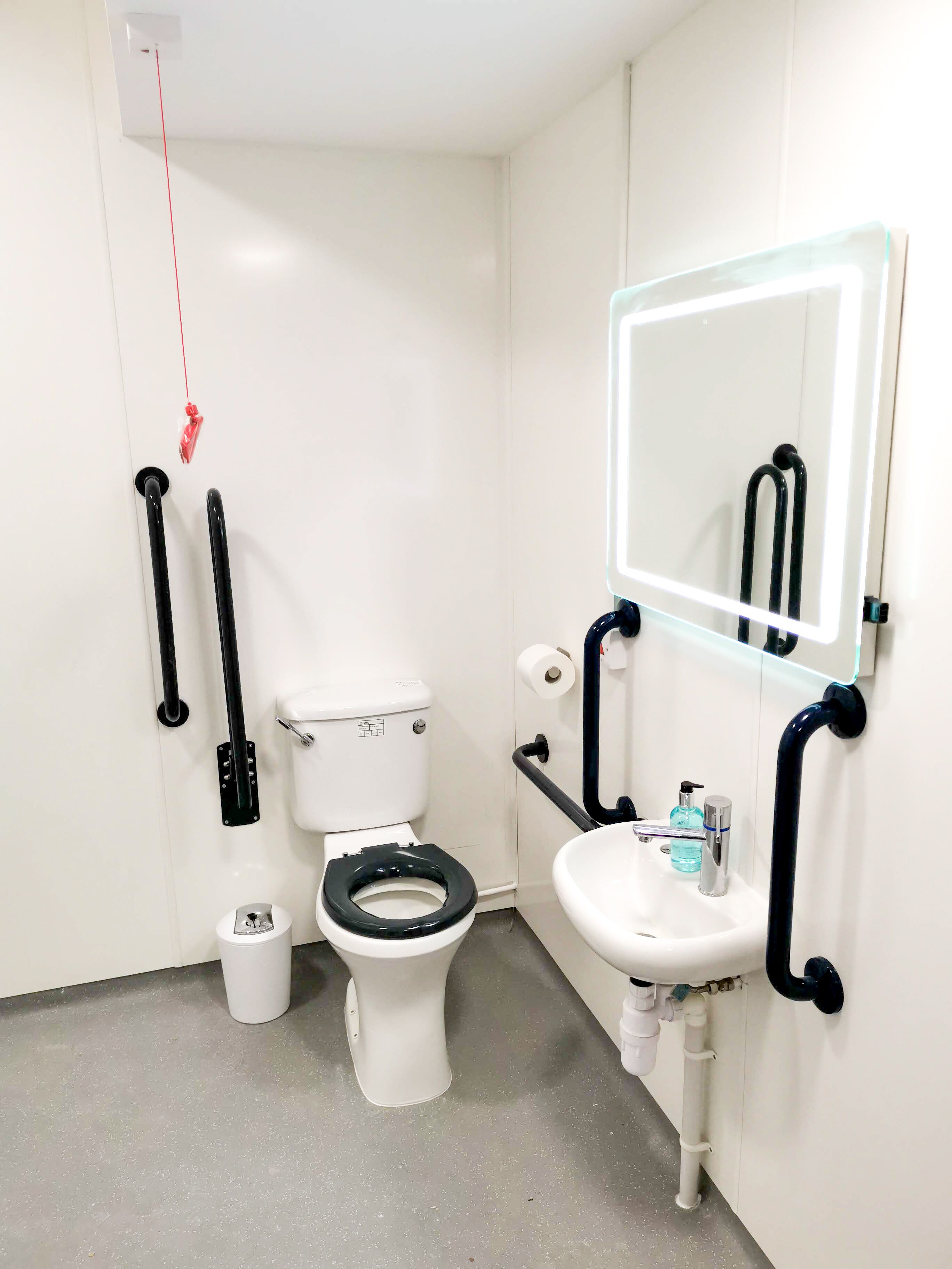 Un baño con inodoro, lavabo y espejo.