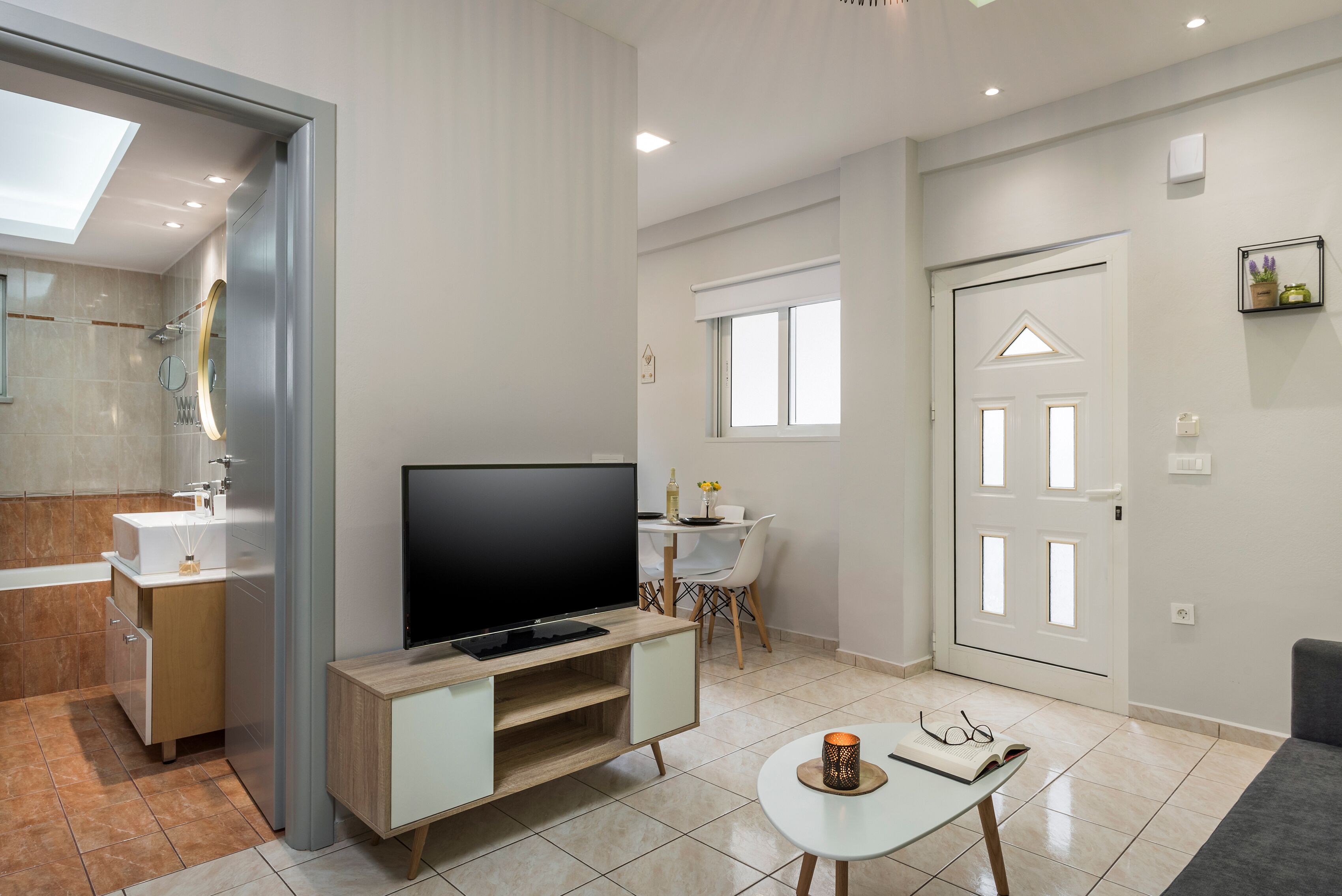 Een moderne woonkamer met een flatscreen televisie, een eettafel en een gezellige zithoek.