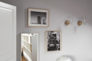 Simple, modern space with a wardrobe, cabinet, and framed photographs on the wall.