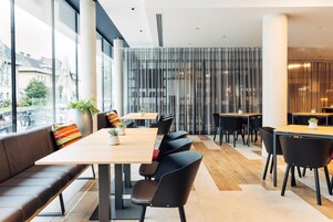 Un comedor moderno con una mesa larga, sillas negras y un banco acolchado.
