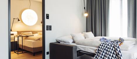 A modern bedroom with a bed, bedside table, and a circular light fixture.