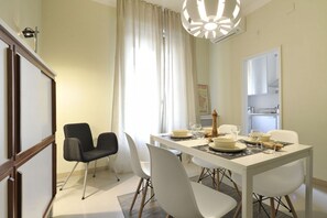 A dining area with a white table set for four, surrounded by white chairs. - UR NEST Borgo San Pietro (Bologna)