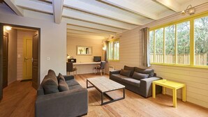 A cozy living room with a sofa, coffee table, and a yellow side table. - Pretty family home aux Americains, spa option (CAP FERRET)