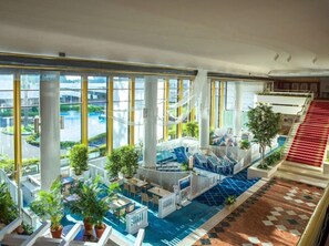 A large indoor pool area with multiple seating areas and a view of the outside. - Tokyo Bay Maihama Hotel First Resort (Urayasu)