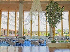 A spacious lobby with a central seating area, large windows, and a prominent tree. - Tokyo Bay Maihama Hotel First Resort (Urayasu)