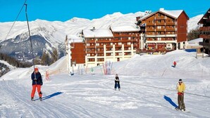 A ski resort with a large lodge, ski lifts, and snowy mountains in the background. - Residence Le Cervin (La Plagne-Tarentaise)