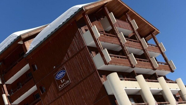 A multi-story hotel with a distinctive wooden facade and balconies. - Residence Le Cervin (La Plagne-Tarentaise)