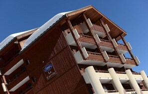 A multi-story hotel with a distinctive wooden facade and balconies.