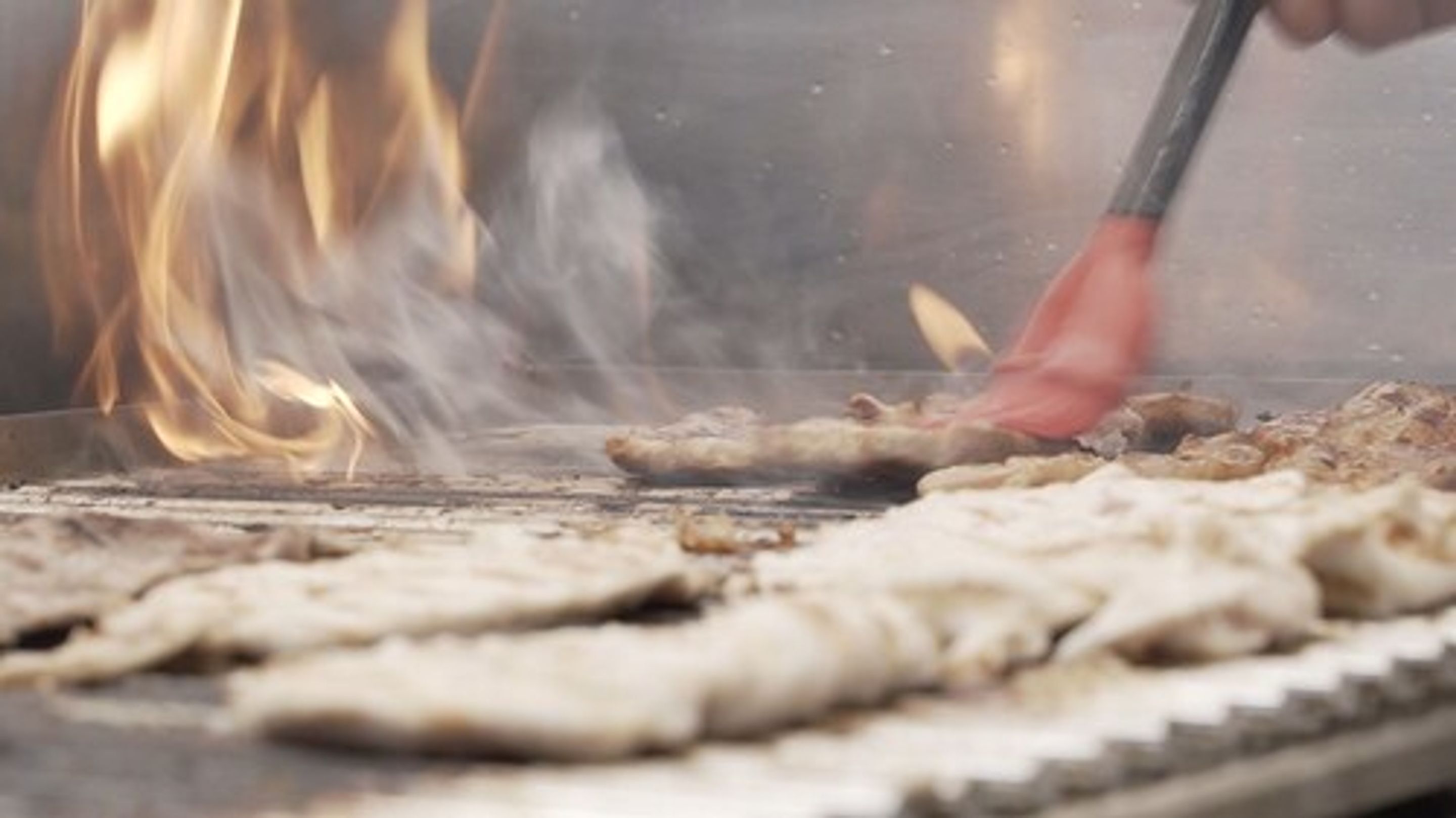 A grill with food being cooked over an open flame.