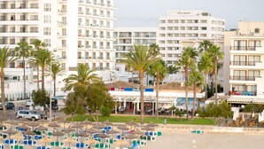 A hotel with multiple floors, outdoor seating, and palm trees. - Hotel Girasol (Sant Llorenc des Cardassar)