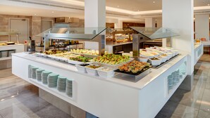 A buffet with various food items and a glass display case. - Hotel Girasol (Sant Llorenc des Cardassar)