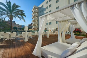 Una piscina techada, una piscina al aire libre, sombrillas