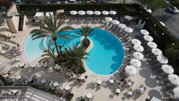 Piscine couverte, piscine extérieure, parasols de plage, chaises longues