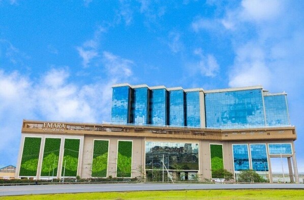 Un edificio moderno con fachada de vidrio y un letrero que dice "EMARA OLE SERIN".