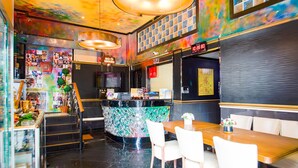 Un restaurante con mostrador, zona de estar y una escalera.