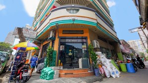 Un edificio de varios pisos con un local comercial en la planta baja.