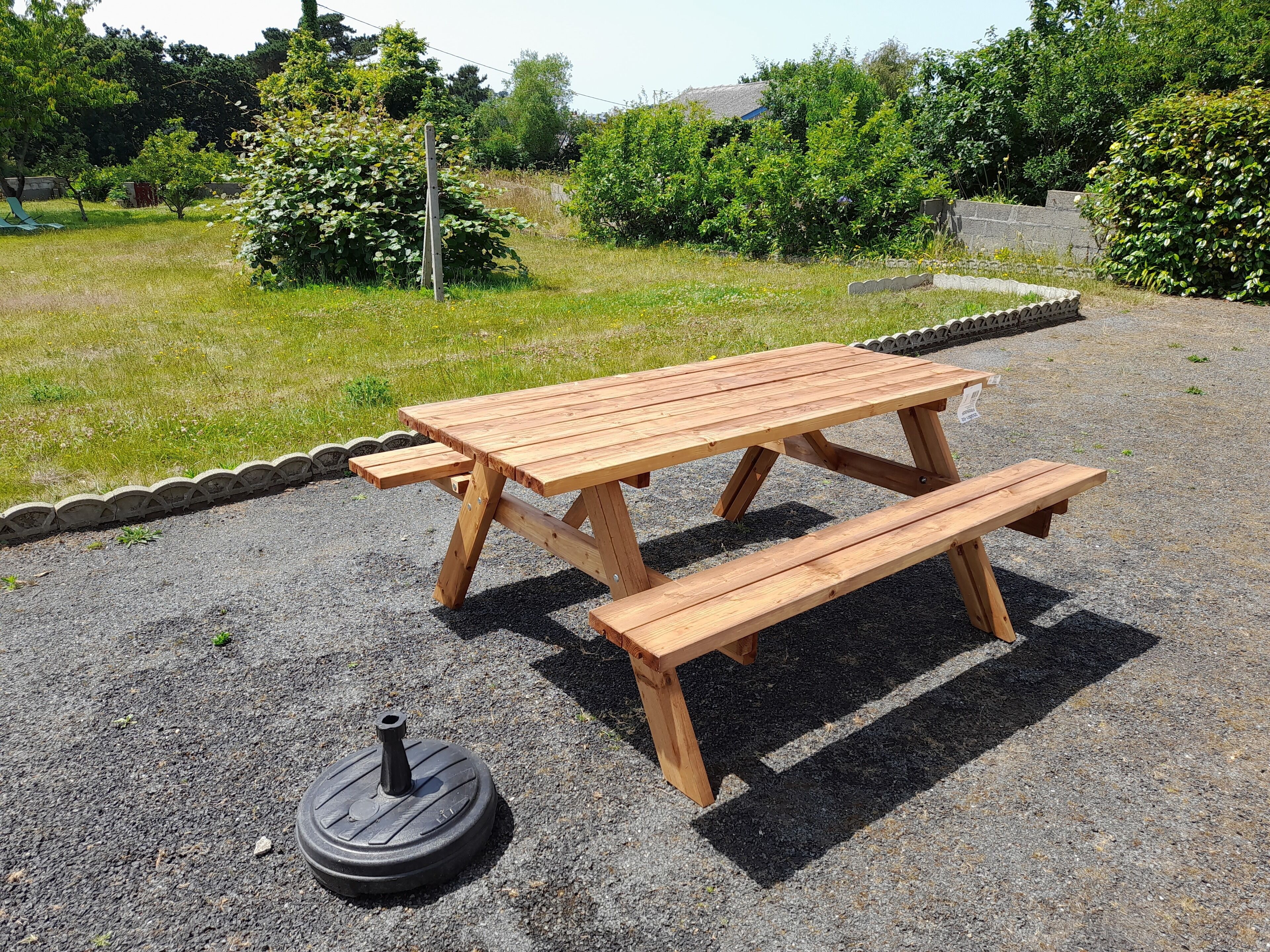Una mesa de picnic de madera con bancos en un parque.
