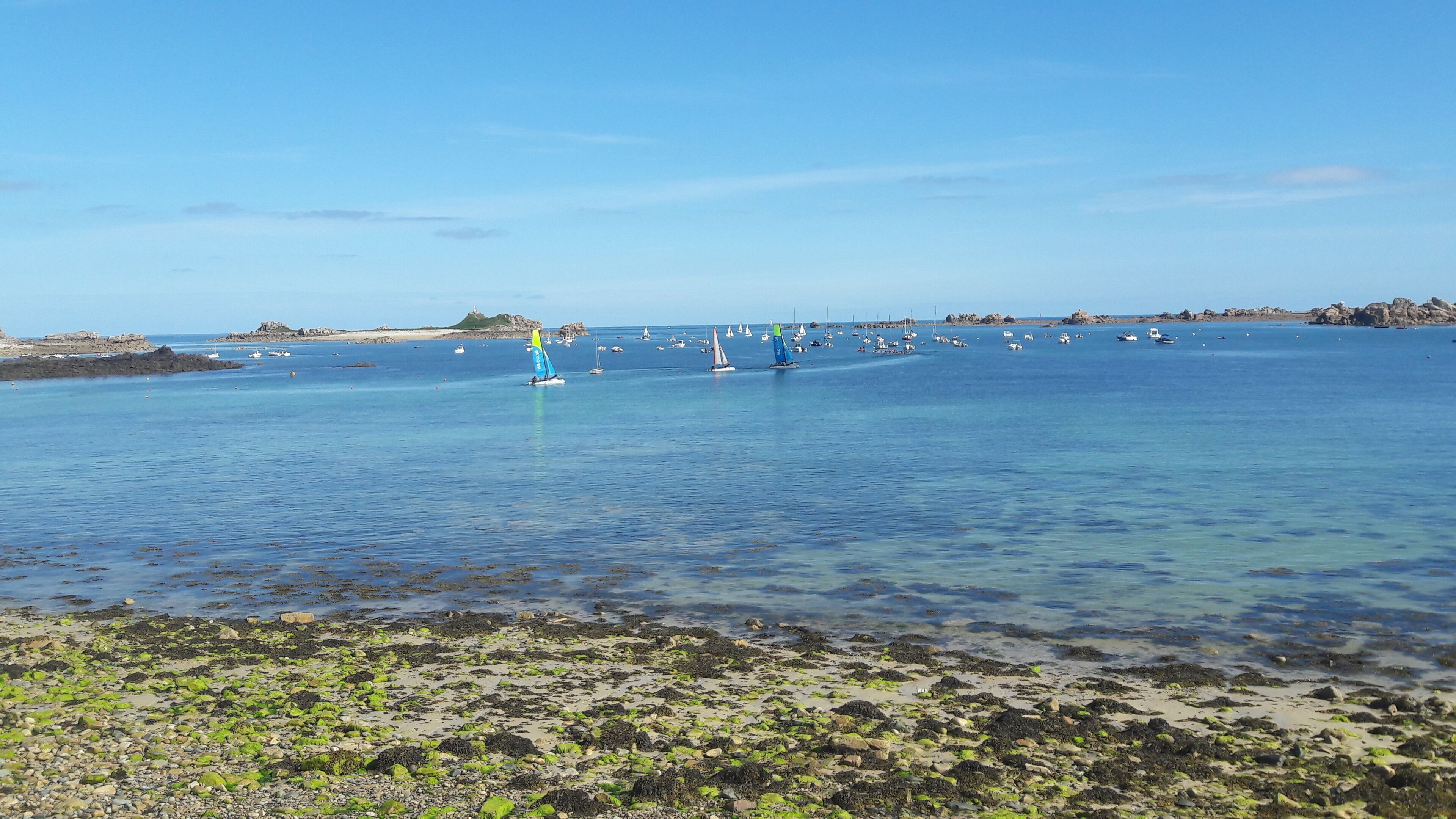 A coastal area with clear water, boats, and rocky shores.