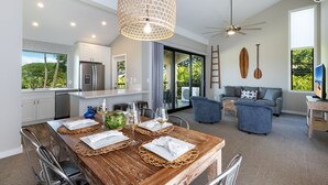 Eine moderne Küche mit Essbereich, großen Fenstern und einem Deckenventilator.
