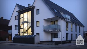 Un bâtiment moderne à deux étages, doté d’un balcon et d’un escalier menant à l’étage supérieur.