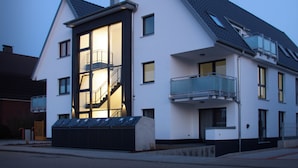 Un bâtiment moderne à deux étages, doté d’un balcon et d’un escalier menant à l’étage supérieur.