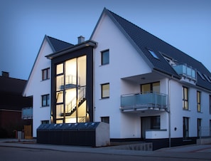 Un bâtiment moderne à deux étages, doté d’un balcon et d’un escalier menant à l’étage supérieur.