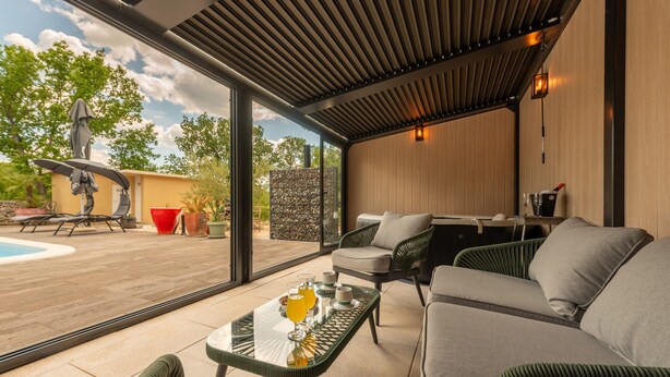 A modern outdoor living area with a pool, lounge chairs, and a glass table with breakfast items. - Villa Zen Promona (Promina)