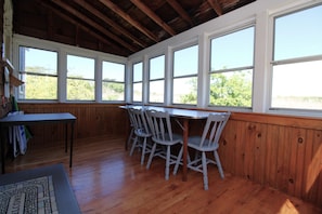 A room with wooden walls, a table, and four chairs.