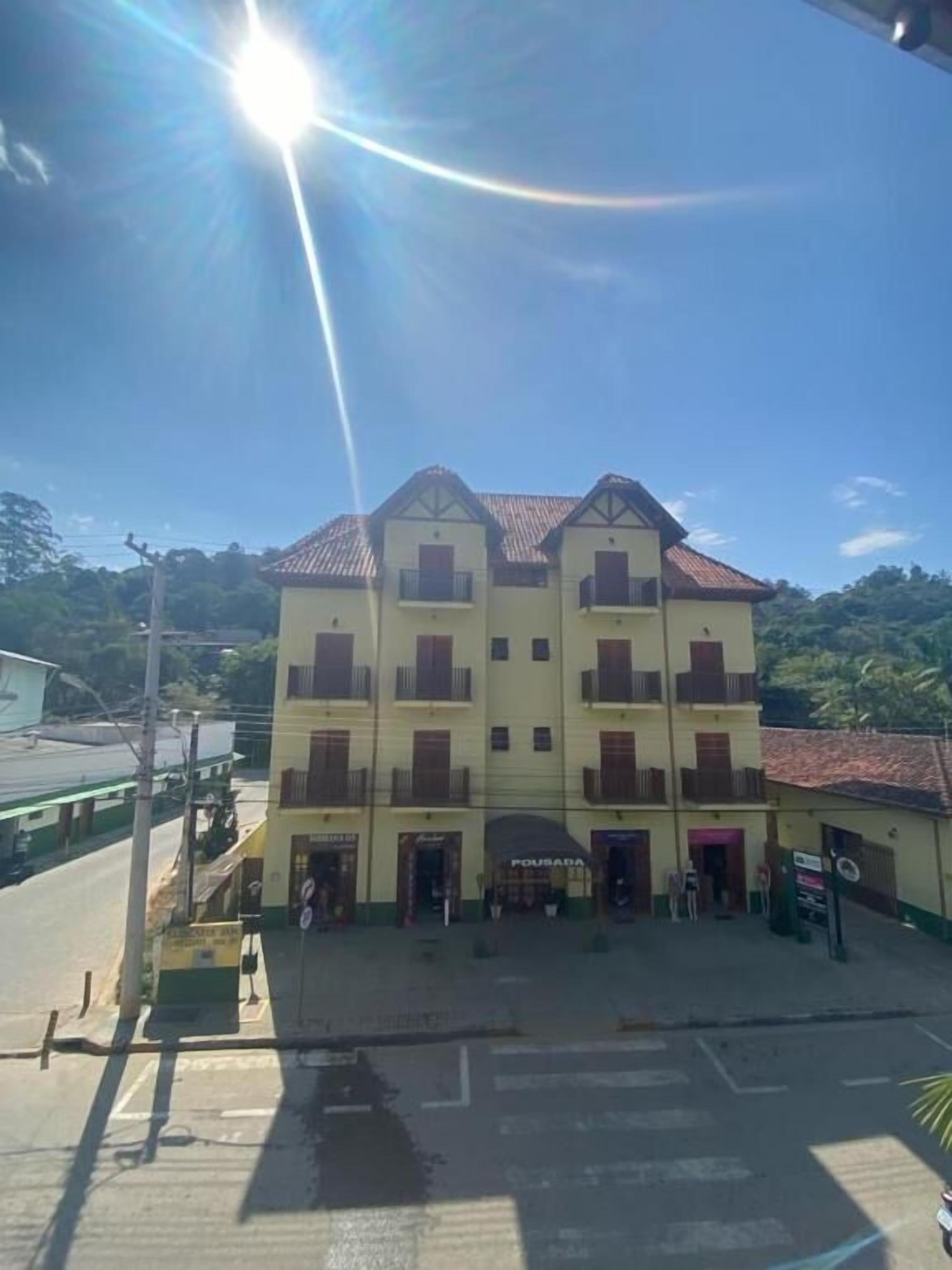 Un edificio de varios pisos con tejado de baldosas y una entrada central.
