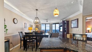 A modern kitchen with granite countertops, wooden cabinets, and a dining area with chairs and a table. - Fantastic Rates! Gulf Front 3Br/2Ba*12th Floor*Phoenix X Unit 1213 (Orange Beach)