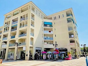 A multi-story hotel with balconies, a central atrium, and outdoor seating areas. - 2 BEDROOMS, IN A LUXURY RESIDENCE, SWIMMING POOL, AIR CONDITIONING, BY THE SEA (Antibes)