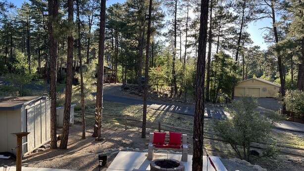 A residential area with a paved driveway, a fire pit, and a red bench. - Mountain retreat with close proximity to lake and town square (Prescott)