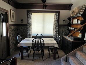 Enjoy meals in this stylish dining area with a stone wall backdrop and a window with floral curtains.
