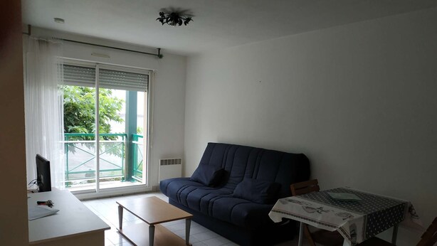Ein Wohnzimmer mit einer Couch, einem kleinen Tisch und einem Sessel.