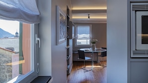 A modern kitchen with a dining area, a large window with a view of a mountain, and a ceiling with exposed beams. - Attico Vista Mare sul Porticciolo di Camogli by Wonderful Italy (Camogli)