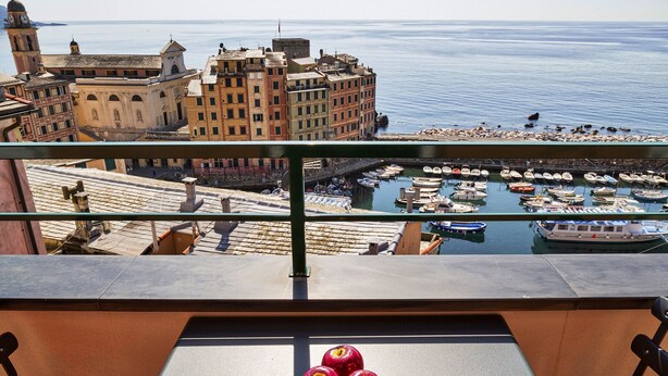 A balcony with a view of a marina, buildings, and a clear sky. - Attico Vista Mare sul Porticciolo di Camogli by Wonderful Italy (Camogli)
