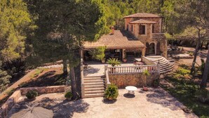 Una villa con patio, mobili da esterno e una scala in pietra che conduce all'ingresso.