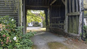 Une construction rustique en bois, avec un chemin de gravier menant à une maison.