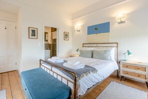 A bedroom with a bed, bedside tables, a bench, a wardrobe, and a mirror. - 3 Bed in Mortehoe (oc-pines) (Mortehoe)