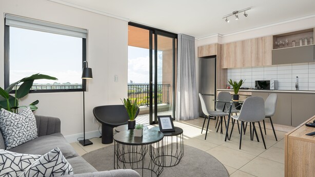 Eine moderne Wohnung mit Balkon, Essbereich und Küche.
