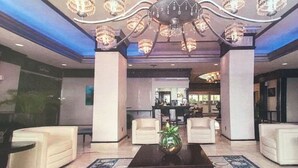 A lobby with a chandelier, white sofas, a coffee table, and a patterned rug. - Best Studio Location In The Building With Unobstructed Water View Balcony (Fort Lauderdale)