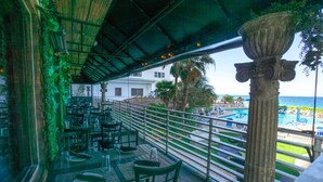 A restaurant with outdoor seating overlooking a pool and ocean view. - Best Studio Location In The Building With Unobstructed Water View Balcony (Fort Lauderdale)