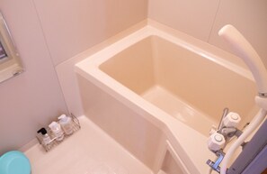 A bathroom with a bathtub, a toilet, and a sink. There are toiletries on the floor next to the toilet. - chupubase Mon Furanos Last Paradise Rokugo abo / Furano Hokkaidō (Furano)