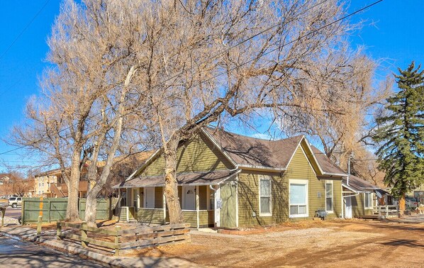 A two-story house with a porch and a garage. - Your Nest Away from Home (Colorado Springs)